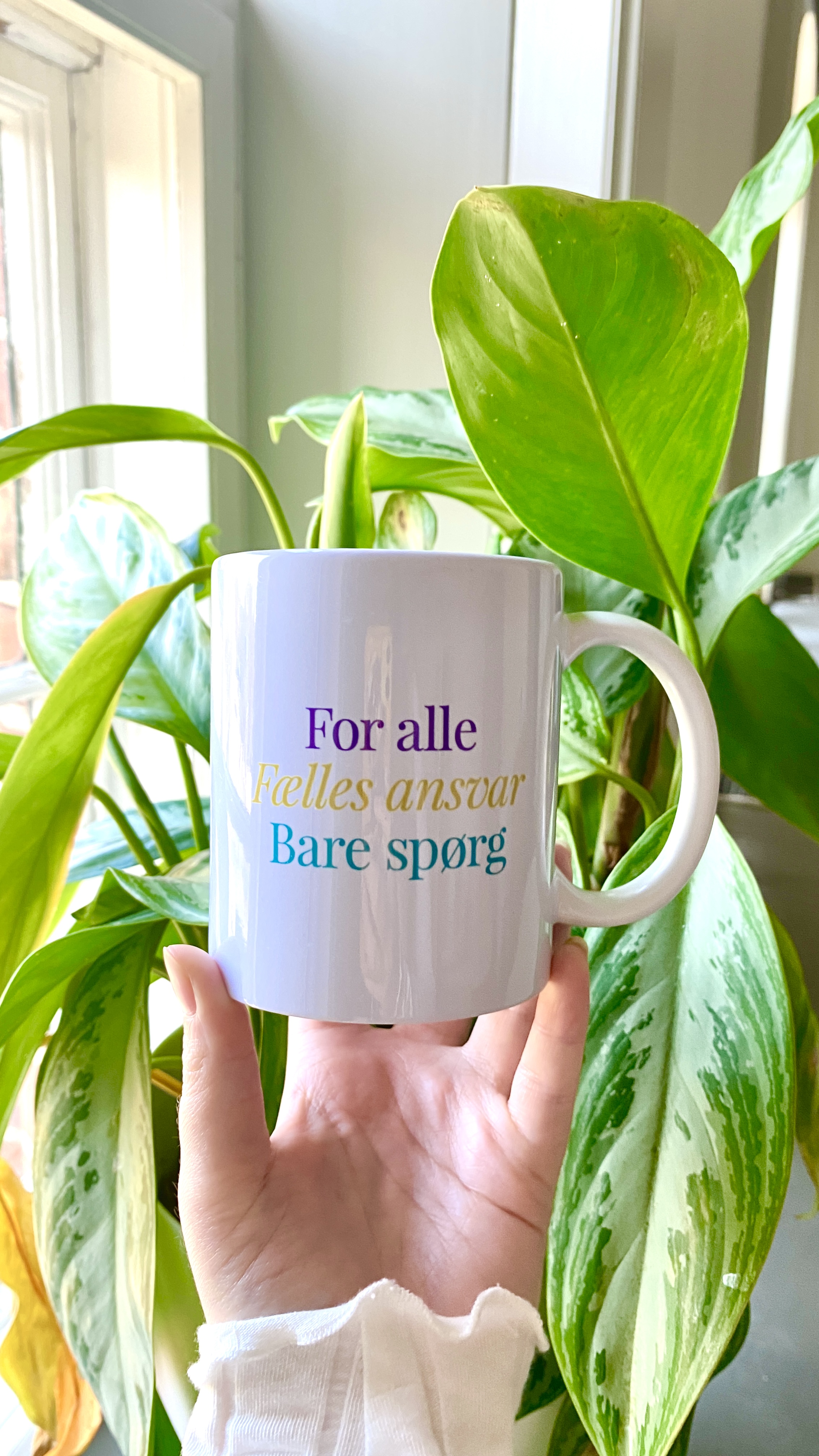 billede af kop med Byens hus motto for alle/fælles ansvar/bare spørg